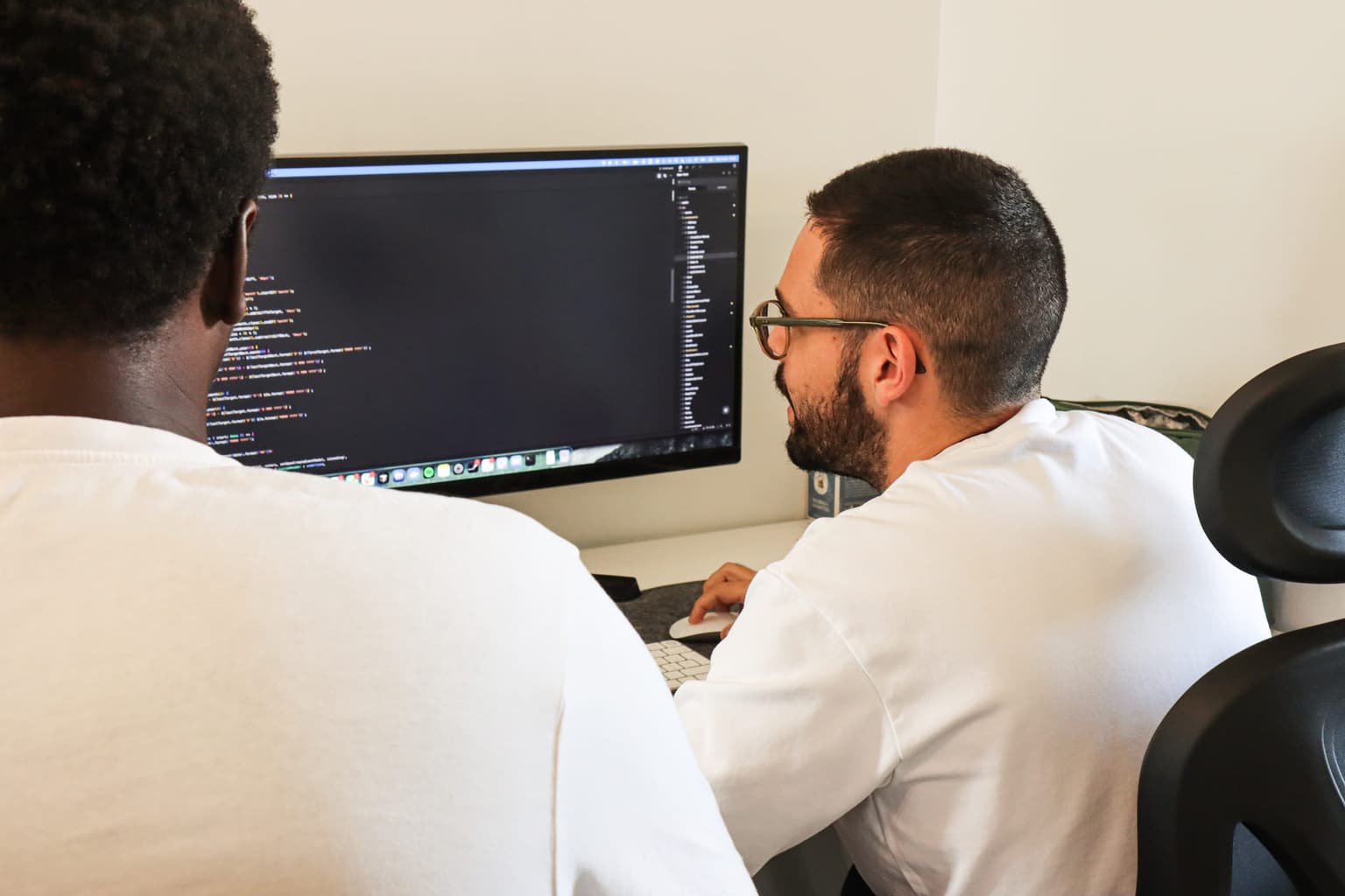 Deux développeurs de Getup Agency travaillent en binôme sur du code, dans les bureaux de La Farlède